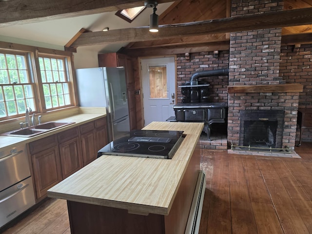 3458 Vt Route 30, Jamaica, VT 05343 - kitchen with a sink, light wood-type flooring, stainless steel refrigerator with ice dispenser, butcher block countertops, and a wood stove