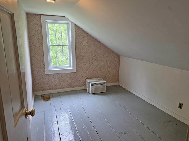 3458 Vt Route 30, Jamaica, VT 05343 - bonus room featuring an AC wall unit, hardwood / wood-style flooring, vaulted ceiling, wallpapered walls, and baseboards