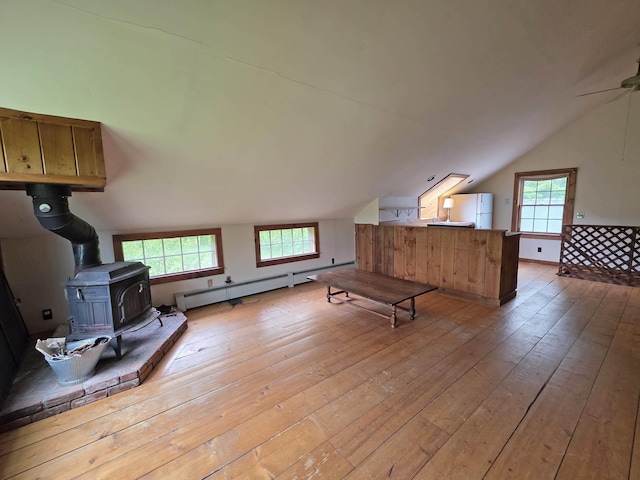 3458 Vt Route 30, Jamaica, VT 05343 - additional living space with vaulted ceiling, light wood-style flooring, a baseboard heating unit, a wood stove, and healthy amount of natural light