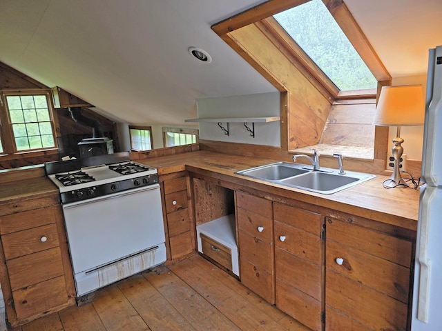 3458 Vt Route 30, Jamaica, VT 05343 - kitchen with white appliances, a sink, vaulted ceiling, brown cabinetry, and a skylight