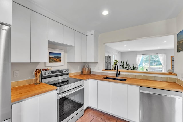 9 Conifer Ct, Burlington, VT 05401 - kitchen featuring stainless steel appliances, a sink, wood counters, white cabinetry, and recessed lighting