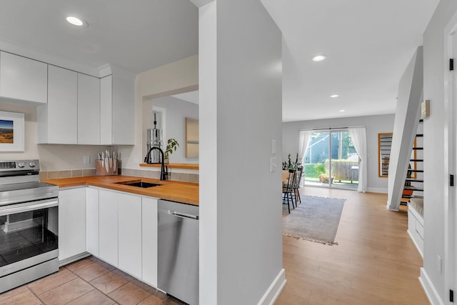 9 Conifer Ct, Burlington, VT 05401 - kitchen featuring stainless steel appliances, a sink, white cabinetry, wooden counters, and recessed lighting