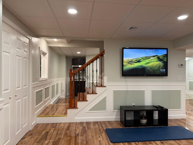 4 Sunblaze Dr, Nashua, NH 03062 - unfurnished living room with a decorative wall, wood finished floors, recessed lighting, stairs, and a wainscoted wall