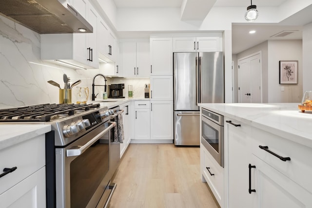 18 Artisan Dr Unit 419, Salem, NH 03079 - kitchen featuring stainless steel appliances, extractor fan, decorative backsplash, white cabinetry, and a sink