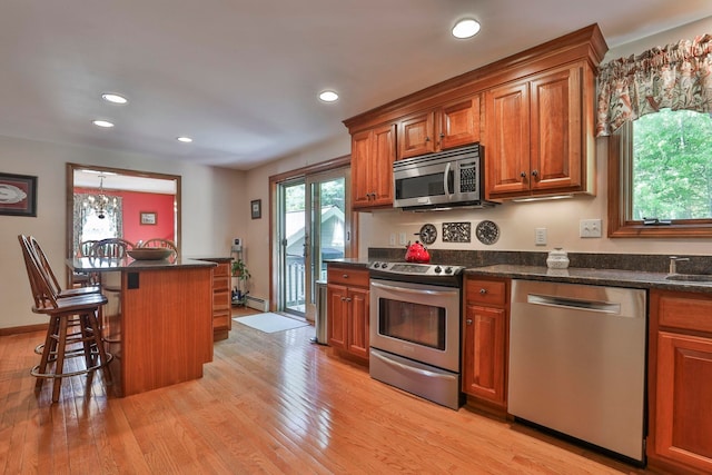 3 Elijah Hill Ln, Londonderry, NH 03053 - kitchen featuring stainless steel appliances, brown cabinetry, a breakfast bar area, and recessed lighting