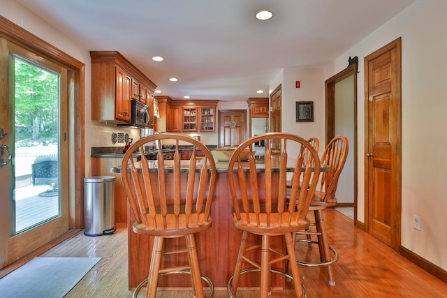 3 Elijah Hill Ln, Londonderry, NH 03053 - kitchen featuring stainless steel appliances, brown cabinetry, light wood-type flooring, recessed lighting, and a breakfast bar area