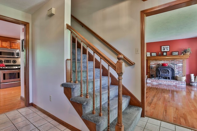 3 Elijah Hill Ln, Londonderry, NH 03053 - stairs featuring tile patterned floors, a wood stove, and baseboards