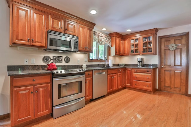 3 Elijah Hill Ln, Londonderry, NH 03053 - kitchen with stainless steel appliances, brown cabinetry, light wood-type flooring, glass insert cabinets, and recessed lighting