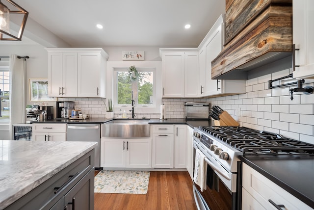 218 Manchester St, Nashua, NH 03064 - kitchen featuring stainless steel appliances, a sink, custom range hood, light wood-type flooring, and recessed lighting