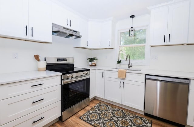 21 Hope Ave, Concord, NH 03301 - kitchen with appliances with stainless steel finishes, under cabinet range hood, a sink, white cabinetry, and light countertops