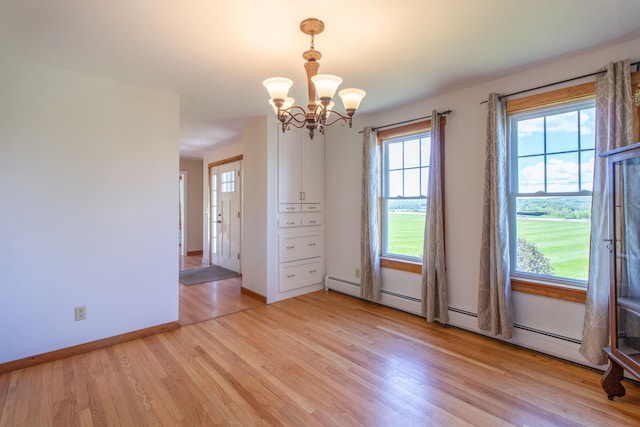 2147 Vt Route 111, Derby, VT 05829 - empty room with a chandelier, light wood-style flooring, a baseboard radiator, and baseboards