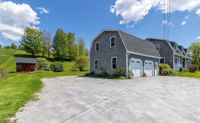 2147 Vt Route 111, Derby, VT 05829 - view of property exterior featuring roof with shingles, a lawn, a gambrel roof, an outbuilding, and a garage