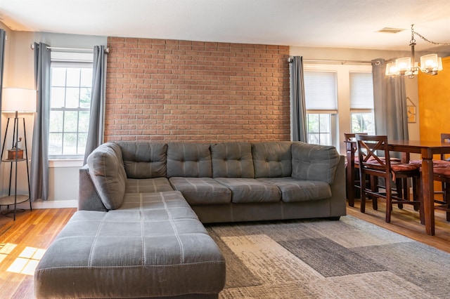 4 Palmer Ave, Plaistow, NH 03865 - living area with wood finished floors, a chandelier, brick wall, and baseboards