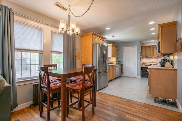 4 Palmer Ave, Plaistow, NH 03865 - dining area with radiator heating unit, a chandelier, recessed lighting, baseboards, and light tile patterned floors