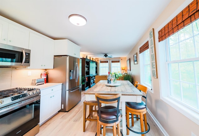 107 Artist Falls Rd, Conway, NH 03860 - kitchen with stainless steel appliances, light wood finished floors, light countertops, and white cabinetry