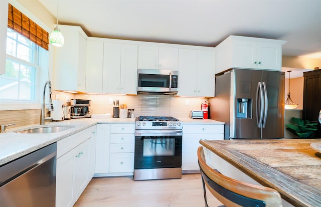 107 Artist Falls Rd, Conway, NH 03860 - kitchen with stainless steel appliances, a sink, light countertops, and white cabinetry
