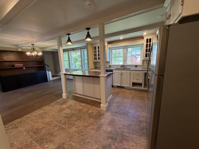 154B Main St, Kingston, NH 03848 - kitchen with freestanding refrigerator, a chandelier, white cabinetry, a sink, and glass insert cabinets