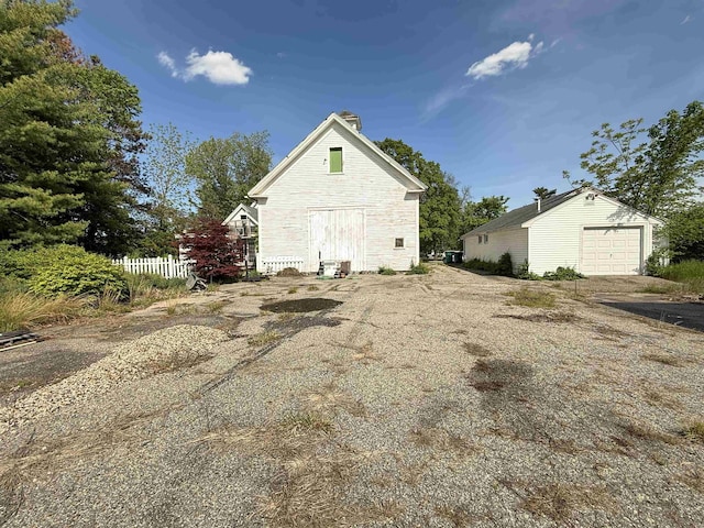 154B Main St, Kingston, NH 03848 - view of home's exterior featuring an outbuilding, a chimney, a garage, and stone siding
