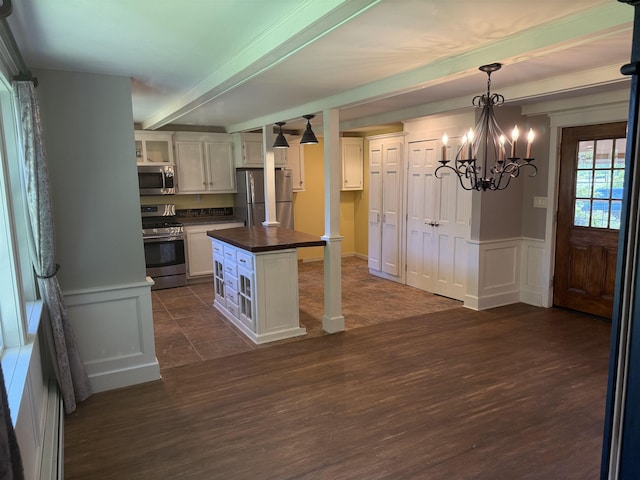 154B Main St, Kingston, NH 03848 - kitchen with appliances with stainless steel finishes, dark wood-style flooring, beamed ceiling, white cabinets, and a decorative wall