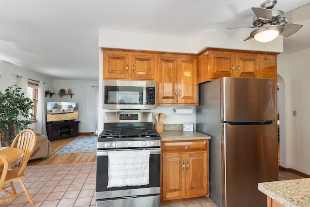 49 Morgan St, Burlington, VT 05408 - kitchen featuring stainless steel appliances, a ceiling fan, brown cabinets, and light tile patterned floors