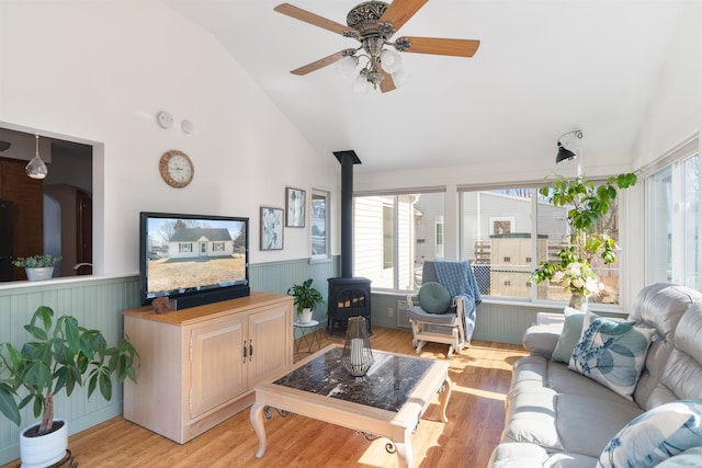 49 Morgan St, Burlington, VT 05408 - living room featuring a wood stove, wainscoting, a ceiling fan, high vaulted ceiling, and light wood finished floors