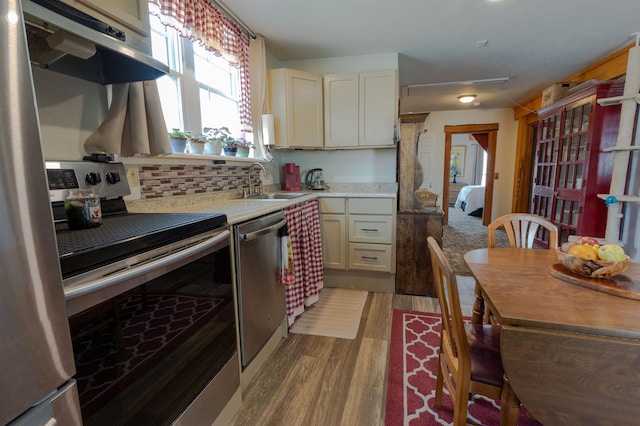 18 State St, Northumberland, NH 03582 - kitchen featuring stainless steel appliances, under cabinet range hood, light countertops, wood finished floors, and a sink
