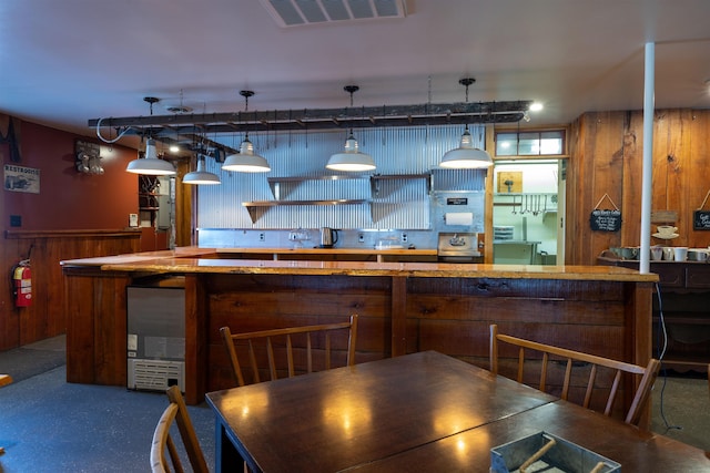 18 State St, Northumberland, NH 03582 - kitchen with wood walls, a kitchen island, pendant lighting, and refrigerator