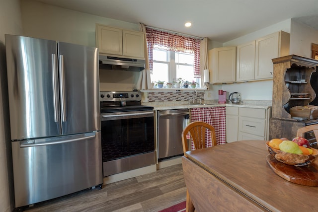 18 State St, Northumberland, NH 03582 - kitchen with appliances with stainless steel finishes, under cabinet range hood, wood finished floors, a sink, and recessed lighting
