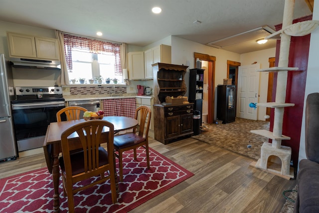 18 State St, Northumberland, NH 03582 - kitchen with appliances with stainless steel finishes, under cabinet range hood, light wood-style floors, light countertops, and recessed lighting