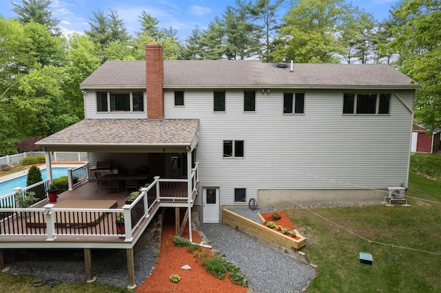 11 Sledding Hill Ln, Lee, NH 03861 - back of property featuring a deck, a chimney, and roof with shingles