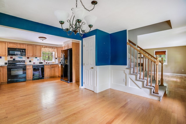 185 Whitford St, Manchester, NH 03104 - kitchen featuring black appliances, a chandelier, light wood-style floors, light countertops, and a sink