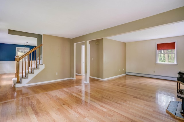 185 Whitford St, Manchester, NH 03104 - unfurnished living room with a baseboard heating unit, light wood-type flooring, stairs, and a chandelier