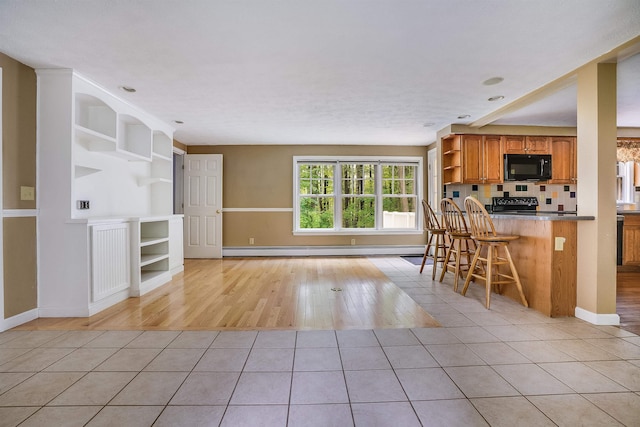 185 Whitford St, Manchester, NH 03104 - kitchen with black appliances, open shelves, brown cabinets, a breakfast bar, and light tile patterned floors