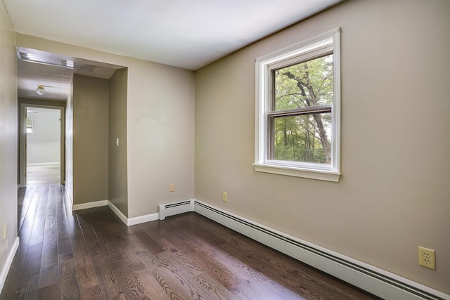 185 Whitford St, Manchester, NH 03104 - spare room featuring baseboard heating, dark wood-type flooring, and baseboards