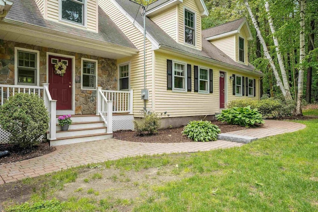 185 Whitford St, Manchester, NH 03104 - doorway to property with stone siding, roof with shingles, a lawn, and covered porch