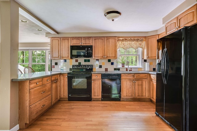 185 Whitford St, Manchester, NH 03104 - kitchen featuring black appliances, a peninsula, healthy amount of natural light, light wood-style floors, and recessed lighting