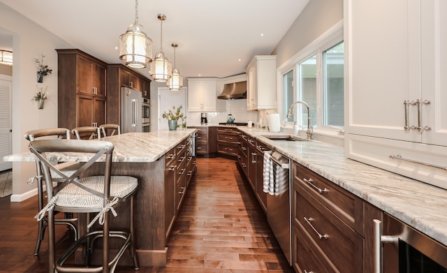 28 Woodvue Rd, Windham, NH 03087 - kitchen with a sink, wall chimney exhaust hood, appliances with stainless steel finishes, dark wood-style floors, and a kitchen breakfast bar