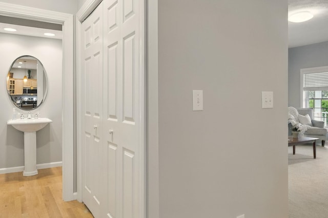 9 Swenson Rd, Bedford, NH 03110 - corridor with baseboards, a sink, and light wood finished floors