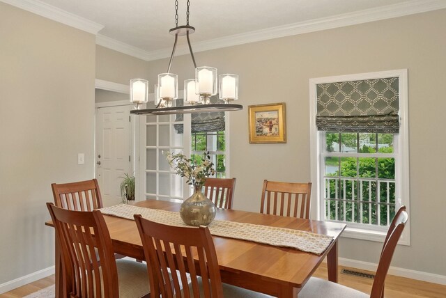 9 Swenson Rd, Bedford, NH 03110 - dining area with light wood finished floors, a chandelier, ornamental molding, and baseboards