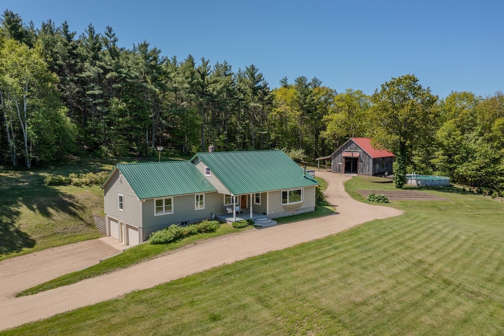 552 Parker Mountain Rd, Strafford, NH 03884 - view of front of property featuring concrete driveway, an attached garage, a front lawn, metal roof, and covered porch
