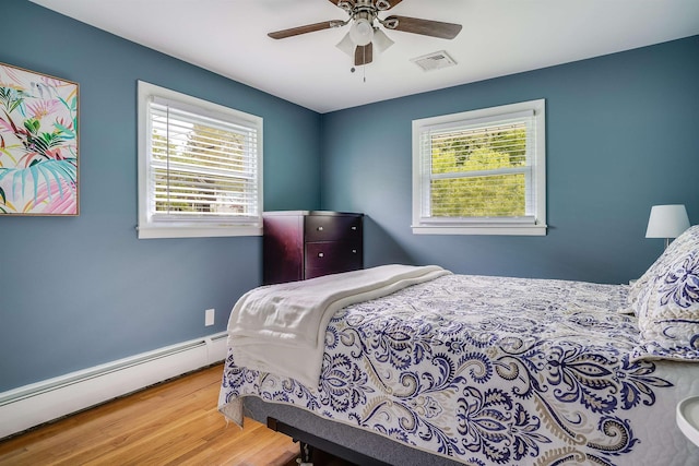 104 Lodge St, Manchester, NH 03104 - bedroom featuring a baseboard heating unit, multiple windows, wood finished floors, and ceiling fan