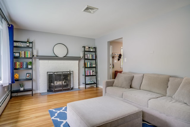 104 Lodge St, Manchester, NH 03104 - living area with wood finished floors, baseboard heating, and a brick fireplace