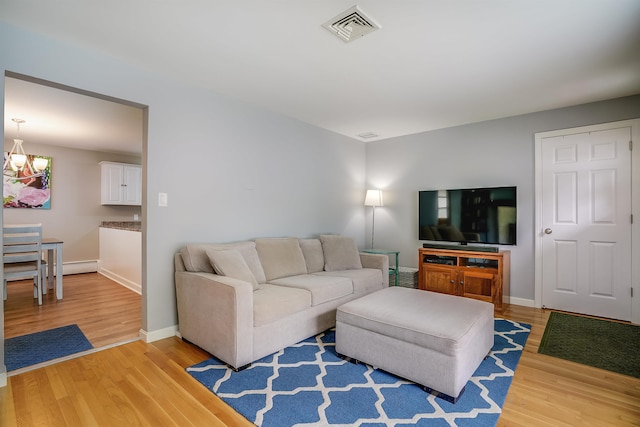 104 Lodge St, Manchester, NH 03104 - living room with light wood finished floors, baseboard heating, and baseboards
