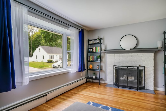 104 Lodge St, Manchester, NH 03104 - living area with baseboard heating, wood finished floors, and a brick fireplace