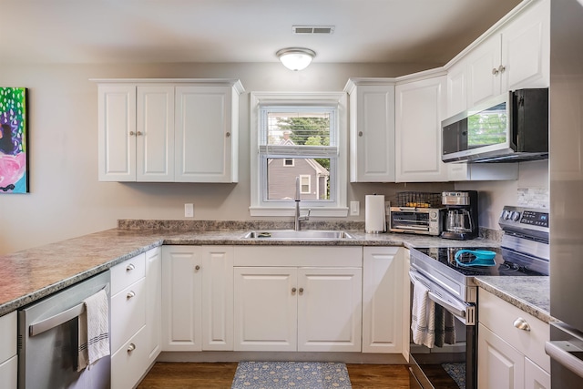 104 Lodge St, Manchester, NH 03104 - kitchen featuring appliances with stainless steel finishes, a sink, and white cabinets