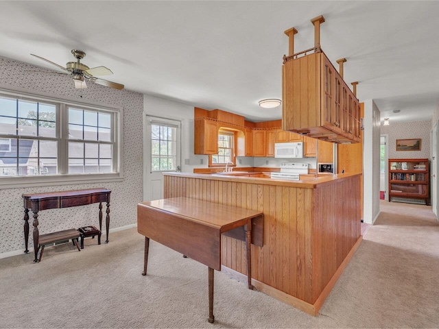 154 Birchcliff Pkwy, Burlington, VT 05041 - kitchen with wallpapered walls, white appliances, light carpet, a ceiling fan, and a peninsula