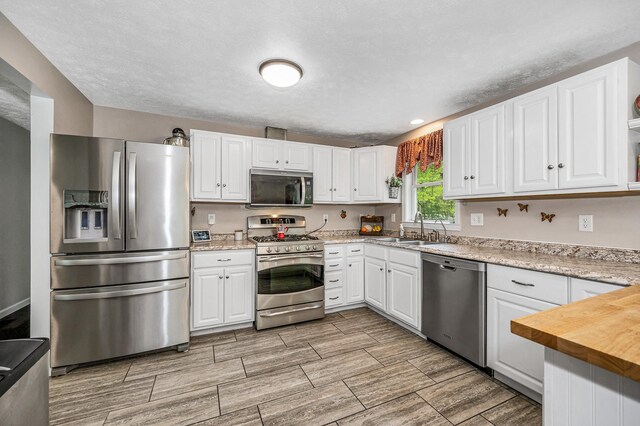 28 Hardy Rd, Londonderry, NH 03053 - kitchen with appliances with stainless steel finishes, a sink, and white cabinets