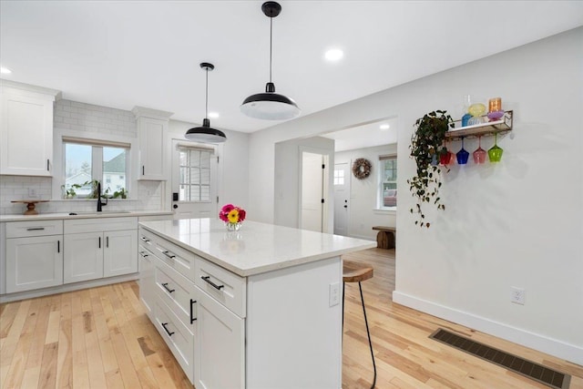 140 S Mast St, Goffstown, NH 03045 - kitchen with a sink, a kitchen bar, light wood-type flooring, backsplash, and recessed lighting