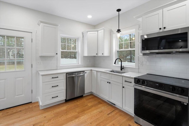 140 S Mast St, Goffstown, NH 03045 - kitchen featuring appliances with stainless steel finishes, a sink, light countertops, and white cabinets
