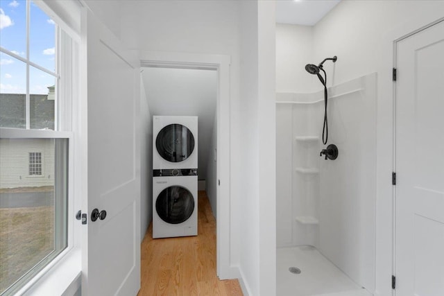 140 S Mast St, Goffstown, NH 03045 - full bathroom featuring stacked washing machine and dryer, a shower, and wood finished floors